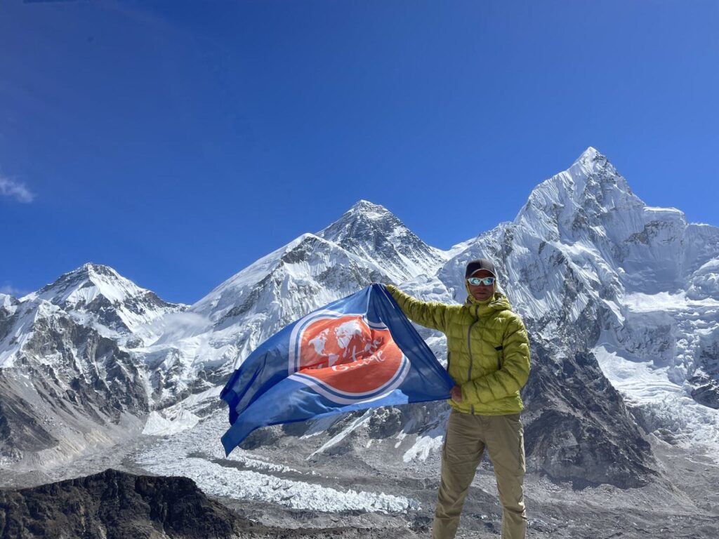 Участник с флагом Mountain Guide в районе Эвереста