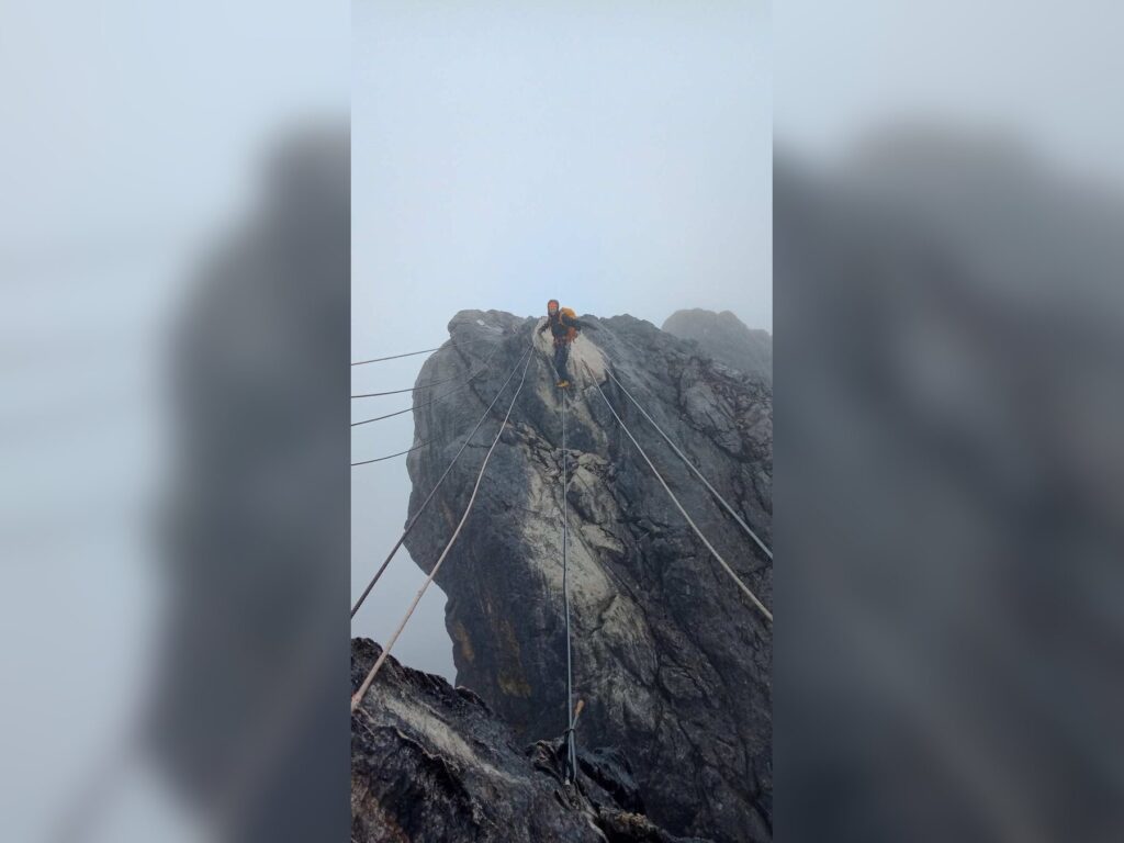 Участник на закрепленных веревках гребня Карстенса