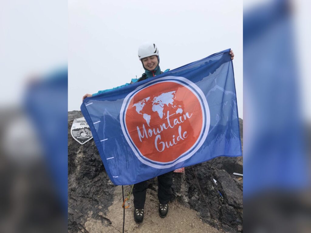 Участник Mountain Guide на вершине пирамиды Карстенса